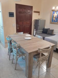 a wooden table and chairs in a room with a bed at Agros house in Ermoupoli