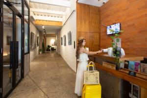 a woman standing at a counter with a yellow suitcase at CASCO 114, king bed Stylish and Cozy apartment near Casco in Panama City