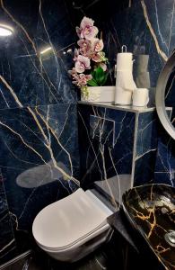 Un baño con inodoro y una pared de mármol azul. en Jacuzzi przy Plaży - Apartament Kołobrzeg, en Kołobrzeg 28 fotos más