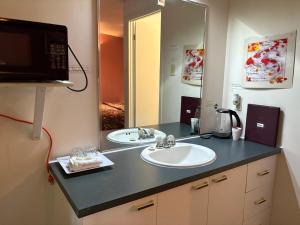 a bathroom with two sinks and a large mirror at Motel Le Voyageur in Saint-Jérôme
