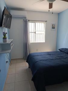 a bedroom with a bed and a flat screen tv at Depto Vacacional Playa in Ciudad Madero +2 photos