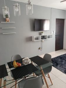 a dining room with a table and chairs and a television at Depto Vacacional Playa in Ciudad Madero