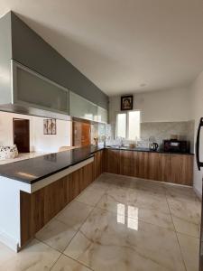 チェンナイにあるWater's egde service apartmentの大きなキッチン(木製キャビネット、カウンタートップ付)
