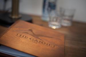 una caja de madera con el nombre de la cámara en una mesa en The Gannet Inn, en St Ives