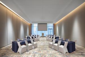 a conference room with tables and chairs and a screen at Wanda Jin Xiaohe Xincheng in Taiyuan