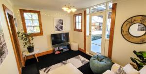 a living room with a couch and a tv at Urban Cottage in Masterton
