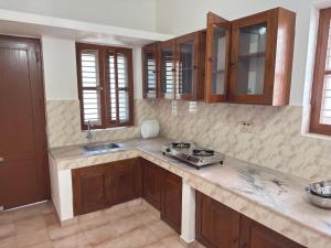 a kitchen with a stove and a counter top at RITU CAPITOL Homestay in Trivandrum
