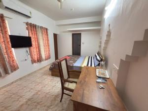 a room with a bed and a table and a bedroom at RITU CAPITOL Homestay in Trivandrum