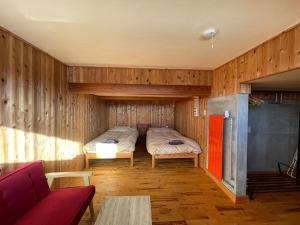 Un dormitorio con una cama en una pared de madera. en 2 Bedroom with spectacular views, en Nozawa Onsen
