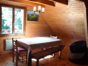 a dining room with a table and some windows at Chalet authentique au cœur de la nature près de Super Besse - FR-1-814-143 in Besse-et-Saint-Anastaise