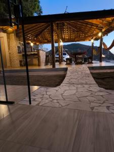 an outdoor patio with a stone floor and a pavilion at Chalé Bela Vista in Munhoz +25 photos