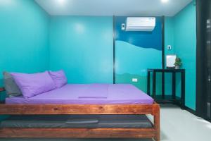 a bed in a room with a blue wall at RedDoorz @ Dolce Cabanas Beach Resort in Zambales