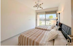 een slaapkamer met twee bedden en een raam bij marina marassi in El Alamein