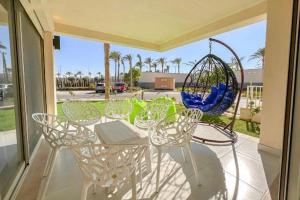 een patio met een tafel en stoelen en een schommel bij marina marassi in El Alamein