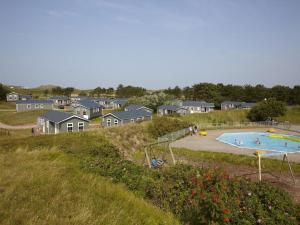 una piscina en un patio con casas al fondo en Chalet in Texel with Private Sauna, en Den Hoorn