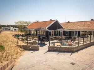 un edificio con un patio con mesas y sillas en Chalet in Texel with Private Sauna, en Den Hoorn