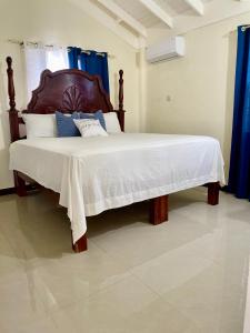 een bed met een houten hoofdeinde in een slaapkamer bij Resort Vibes Getaway - Colbeck Manor Old Harbour - Gated, pool, gym in Old Harbour
