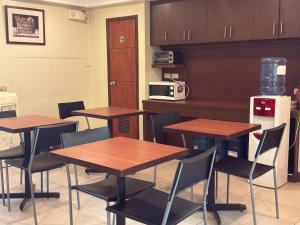 a kitchen with wooden tables and chairs and a counter at Joyce Apartelle Mandaluyong in Manila
