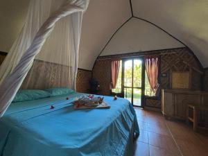 a bedroom with a bed with blue sheets and candles on it at BARENG -BARENG gili bungalows in Gili Meno