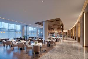 a restaurant with tables and chairs in a building at Wanda Jin Xiaohe Xincheng in Taiyuan