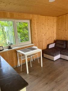a living room with a table and a couch at Atostogų namelis Stebuliuose in Stebuliai