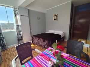 a room with a table and two chairs and a bed at Hotel El Sol de Carhuaz in Carhuaz +5 photos