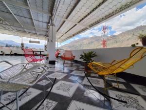 a patio with chairs and tables and mountains in the background at Hotel El Sol de Carhuaz in Carhuaz