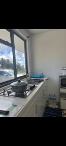 a kitchen with a stove with a pan on the counter at Fare Kahaia Rangiroa in Avatoru