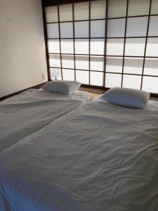 a pair of beds in a room with windows at Emeraldia in Tateyama +12 photos