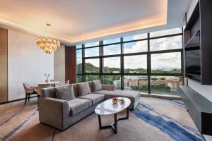 深圳Mercure Shenzhen Longgang的带沙发和大窗户的客厅
