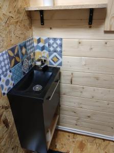 a bathroom with a black sink and a wall at Le chalet des Sarteaux in Ville-sur-Lumes