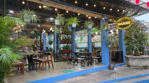 a restaurant with tables and chairs and potted plants at SHARE Hostel & Coffee in Hue
