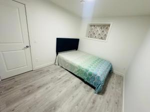 カルガリーにある2 bedroom Basement Suiteの隅にベッドが置かれた小さな寝室