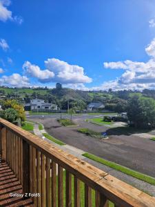 a view of a road from a wooden deck at Welcomebay Haven in Tauranga +3 photos