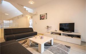 a living room with a black couch and a tv at Amazing Home In Okrug Gornji in Trogir