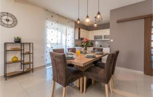 een keuken en eetkamer met een houten tafel en stoelen bij Lovely Home In Biograd Na Moru in Biograd na Moru