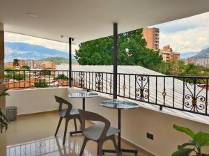 a balcony with two tables and chairs and a view at Casa Hotel La Bonita in Medellín