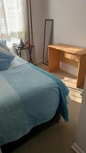 1 dormitorio con cama y escritorio de madera en Solsol, en Antofagasta 4 fotos más
