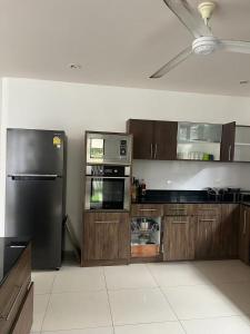 une cuisine avec des armoires en bois et un réfrigérateur en acier inoxydable dans l'établissement Baan thai pool villa pattaya, à Jomtien Beach