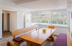 ein Esszimmer mit einem Holztisch und einem großen Fenster in der Unterkunft Stunning Home In Klis in Klis