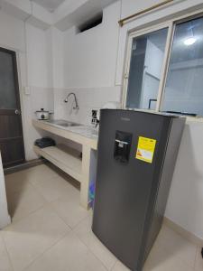 a small refrigerator in a kitchen with a sink at Refugio Del Mar in Burrero