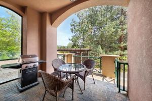 a patio with a table and chairs and a grill at Borgata Lodge Resort in Kelowna