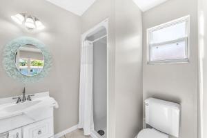 a white bathroom with a sink and a mirror at 721 Java Rd in Cocoa Beach