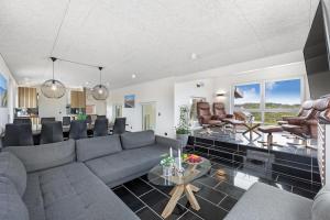 una sala de estar con un sofá y una mesa en Family-Friendly Holiday Home With Indoor Pool And Outdoor Spa 100 Meters From The North Sea, en Ringkøbing