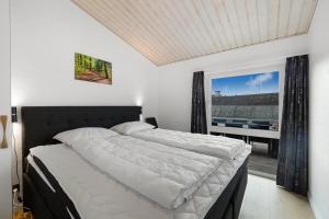 Un dormitorio con una cama grande y una ventana. en Family-Friendly Holiday Home With Indoor Pool And Outdoor Spa 100 Meters From The North Sea, en Ringkøbing 19 fotos más