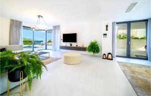 ein weißes Wohnzimmer mit einem TV und einem Sofa in der Unterkunft Amazing Home In Marina With Sauna in Marina