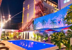 a hotel with a swimming pool at night at Papabo Backpackers Mactan in Lapu Lapu City