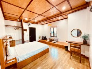 a bedroom with a bed and a table and a mirror at Ohayo Tam Coc Homestay in Ninh Binh