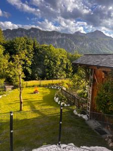 a fence in front of a yard with a mountain at AtterseeSuite in Unterach am Attersee