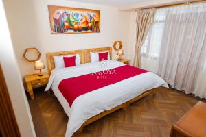a bedroom with a large bed with a red blanket at Hotel LaJoya in Otavalo +39 photos